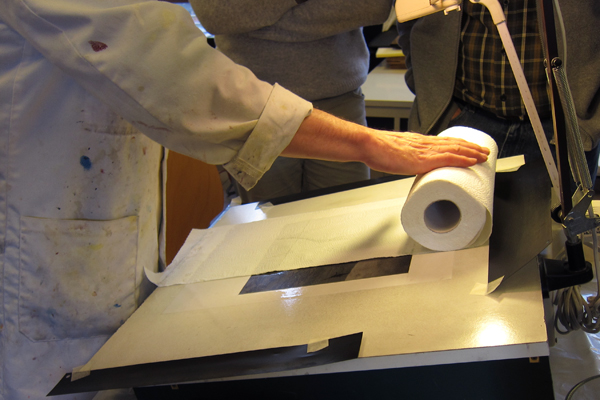 After being soaked the paper gets placed on your working space and attached, with normal household paper you can get rid of the excess water; you only want the swollen gelatine to be wet to repel the ink.